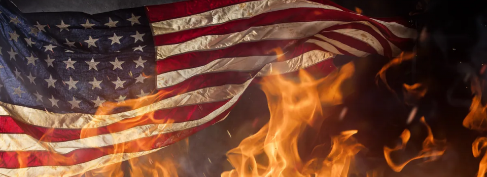 American flag waving with flames surrounding it
