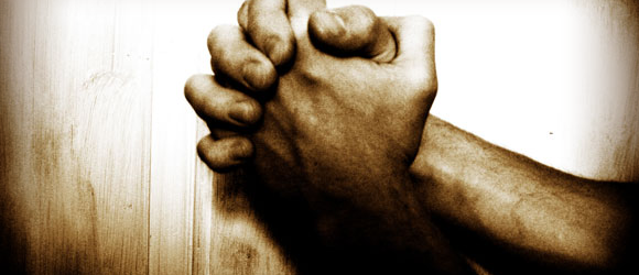 The image show a set of hands intertwined in prayer